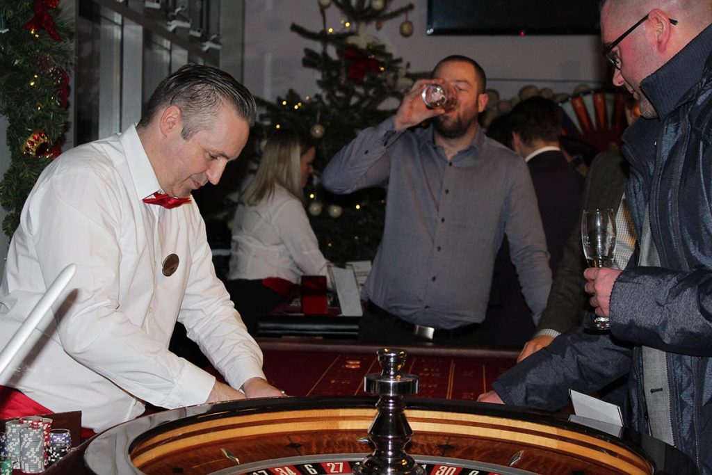 Man drinking while playing roulette at Christmas fun casino night