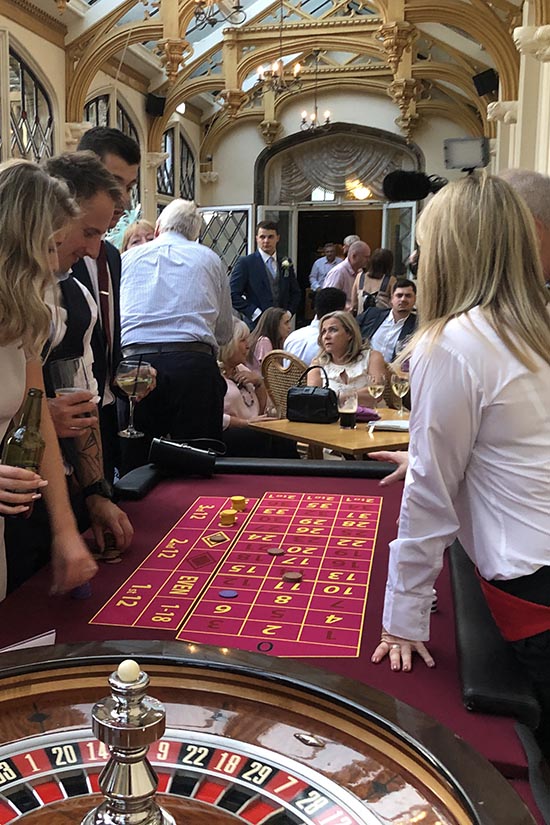 Players at roulette table at wedding casino party